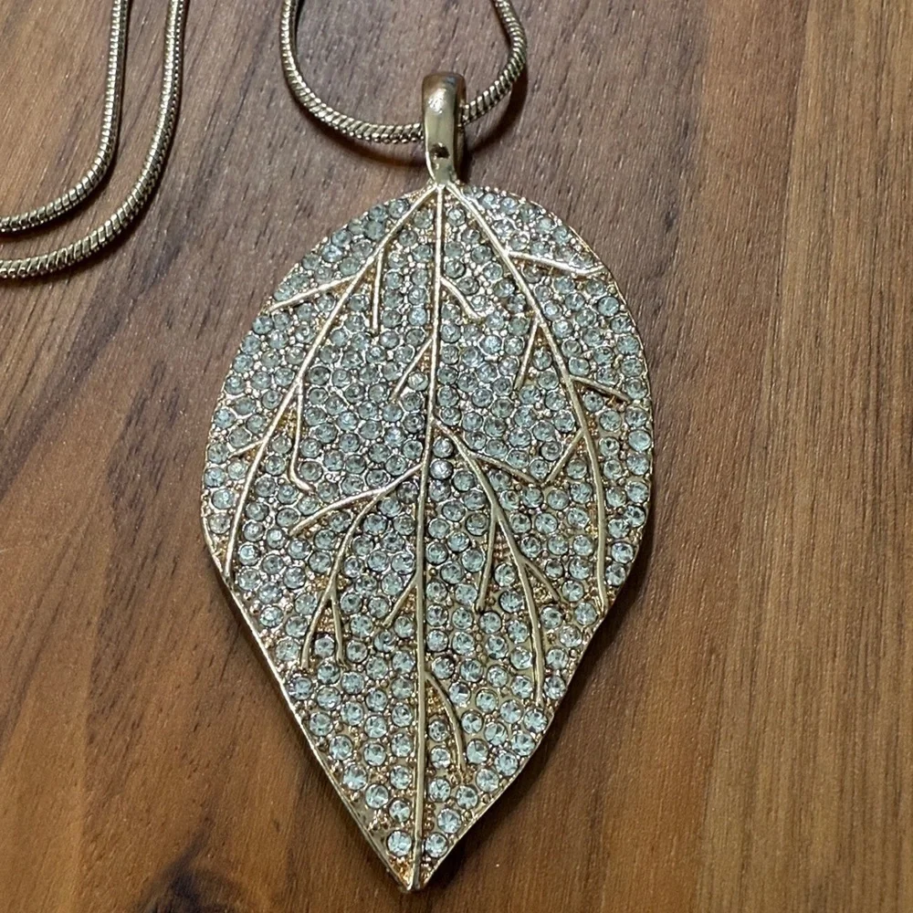 Aldo Gold Tone Clear Rhinestone Long Necklace with Leaf Feather Pendant